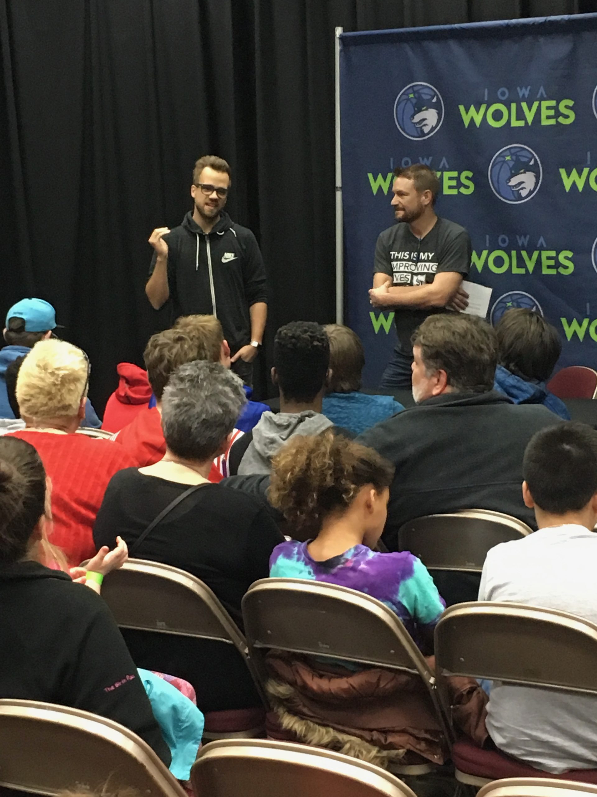 Panelists speaking to an Iowa Wolves audience